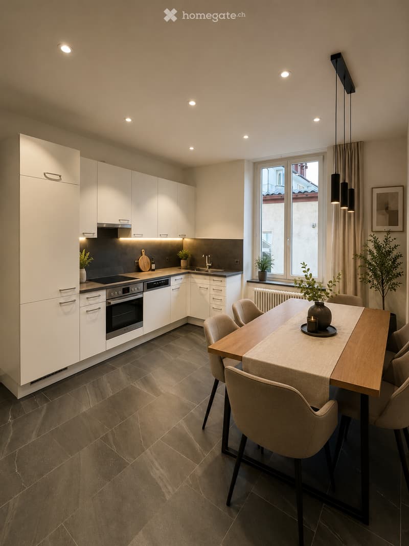 Modern kitchen with white cabinetry, stainless steel appliances, a central island, and a dining area with a wooden table and chairs. The space features recessed lighting, a large window with a view, and decorative plants.
