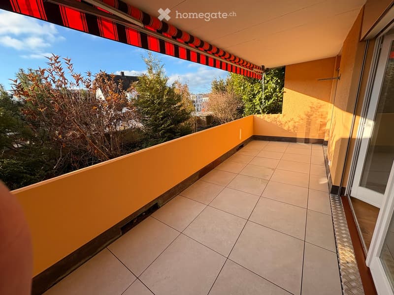 A balcony with tiled flooring and a retractable awning