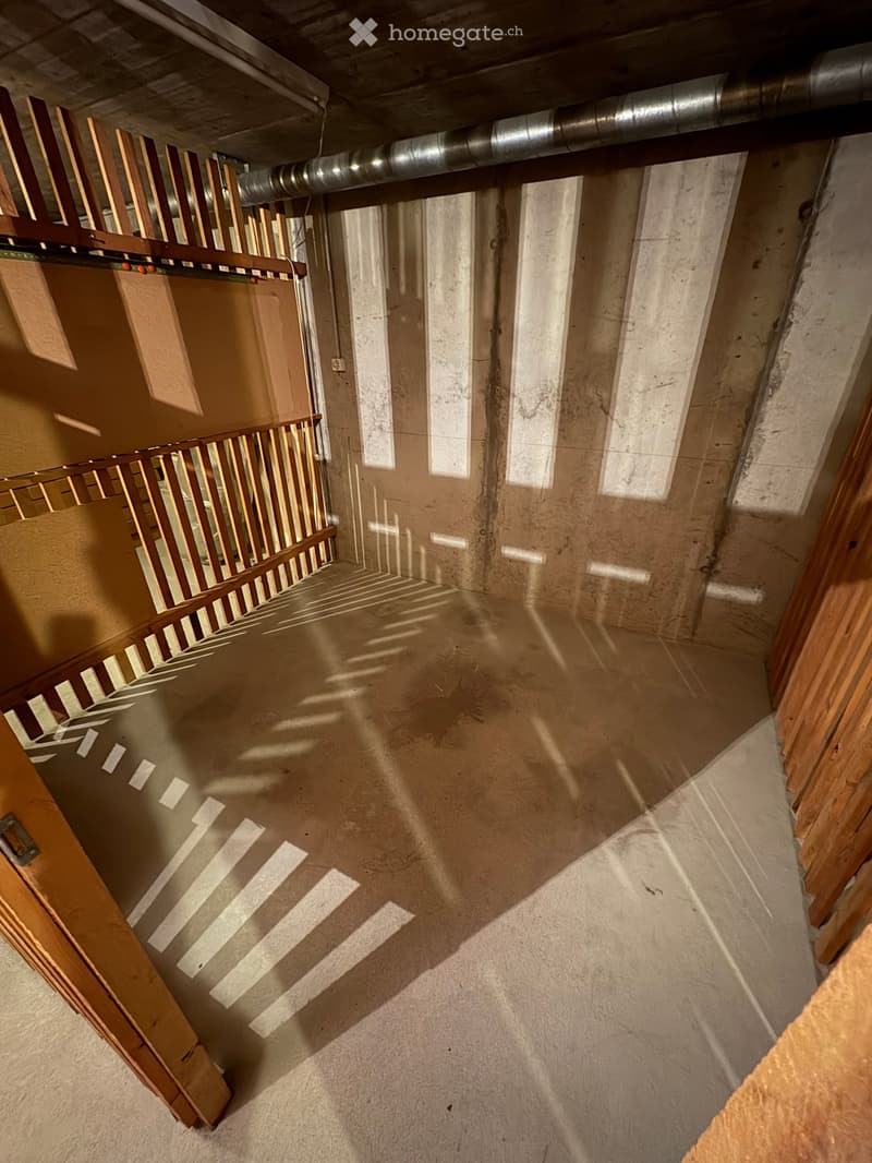 wooden rails on one side, concrete floor, concrete walls