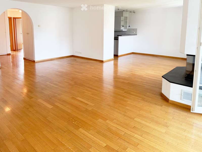 Empty room with light wooden flooring, white walls, and an open doorway leading to another area. The room is unfurnished and has a clean, minimalist design.