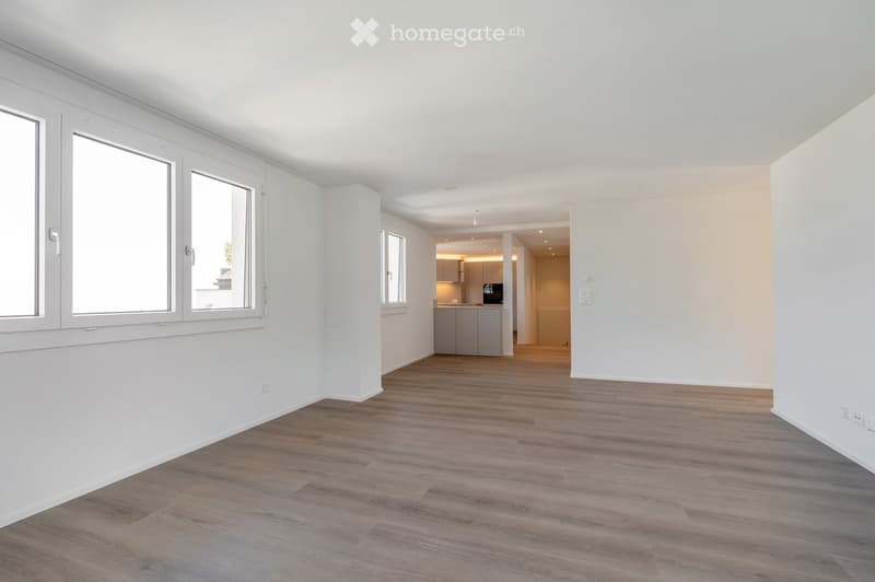 Empty room with white walls, wooden floor, and large windows. No furniture or equipment.
