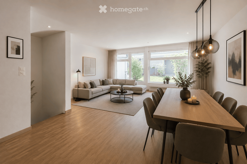 Open-plan living and dining area with light wood flooring, a sectional sofa, a coffee table, a dining table with chairs, and modern lighting fixtures.