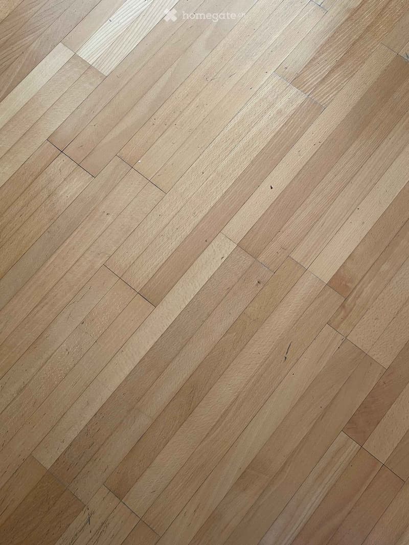 Empty room with light wooden flooring, no furniture or equipment visible.