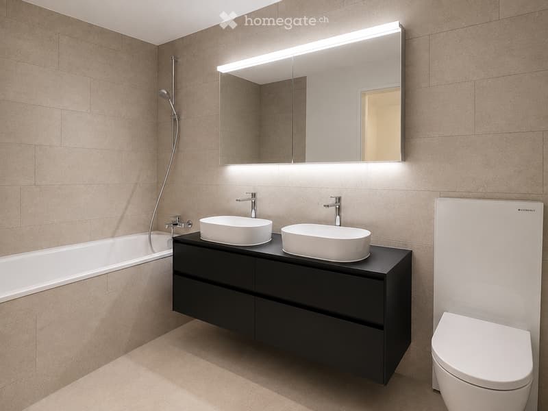 Modern bathroom with beige tiles, a black vanity cabinet with two sinks, a large mirror with LED lighting, a bathtub, and a toilet.