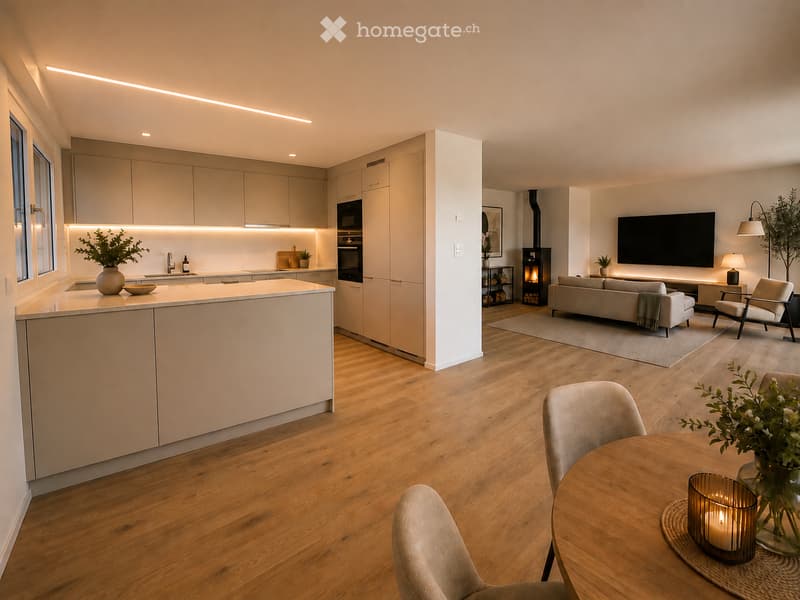 Open-plan living and dining area with a modern kitchen, light wood flooring, and integrated appliances. Features a sofa, dining table with chairs, and decorative elements like vases and candles.