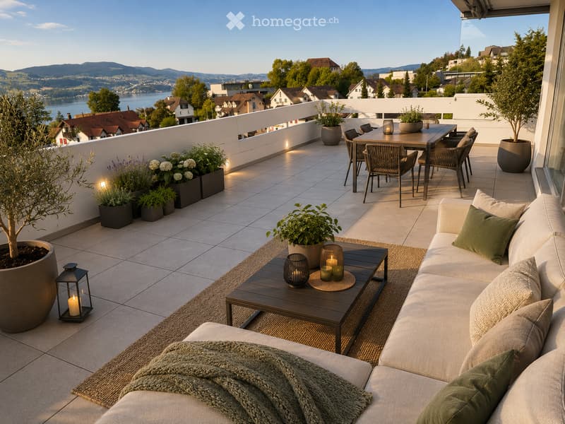 Balcony with a view of a lake and surrounding landscape, featuring a sofa, coffee table, dining table, chairs, and decorative lanterns.