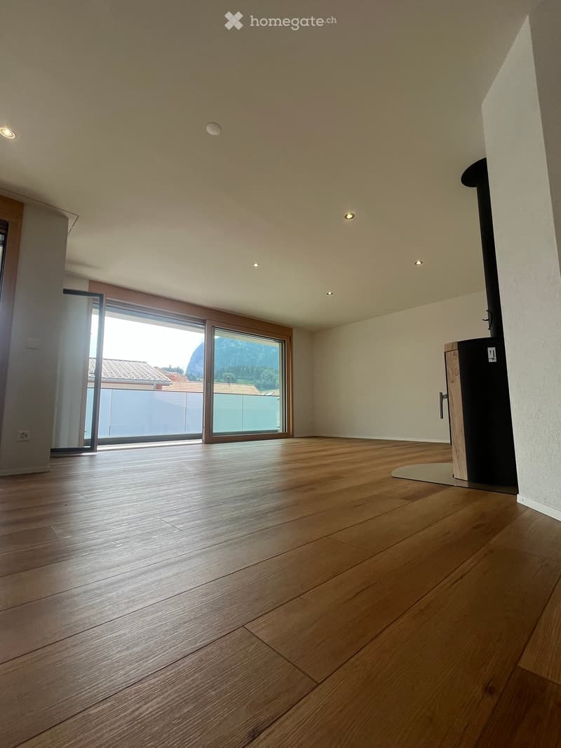 Empty room with wooden flooring, large windows, and recessed lighting. No furniture or equipment present.