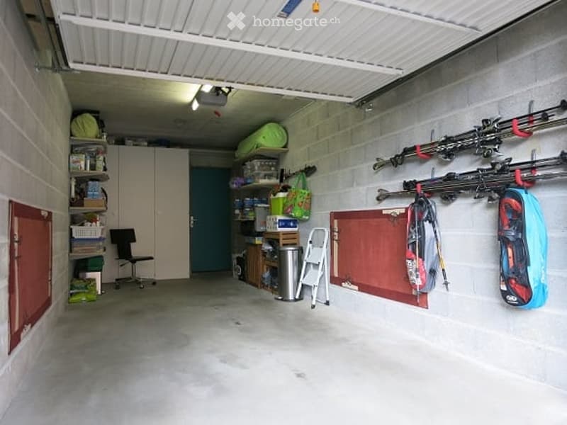 {"visible_features": ["Garage"], "type": "Garage", "objects": [], "description": "Clean, organized garage with concrete floor, white ceiling, storage shelves, and various items including skis, bags, and tools.", "localized_descriptions": {"EN": "Clean, or