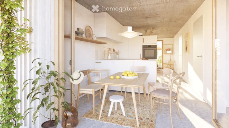 A modern, minimalist kitchen and dining area with white cabinets, a wooden dining table, and chairs. The space features a hanging pendant light, a potted plant, and a decorative vase on the floor.