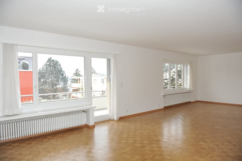 open room with balcony, large windows, wooden parquet flooring, white radiators