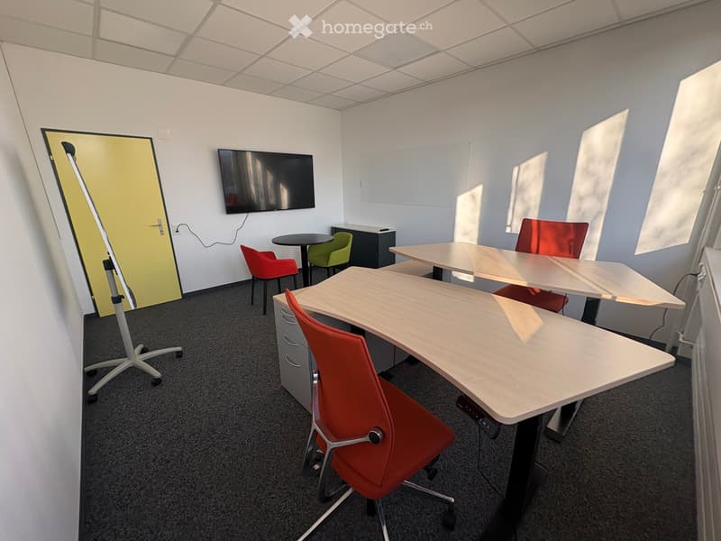 empty room with desks, chairs, and a television