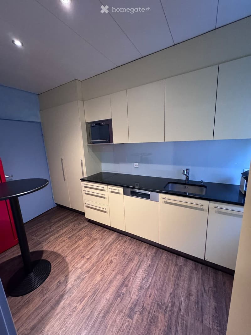 kitchen with built-in oven, sink with faucet, dishwasher, black countertop, microwave, cupboards, wooden floor