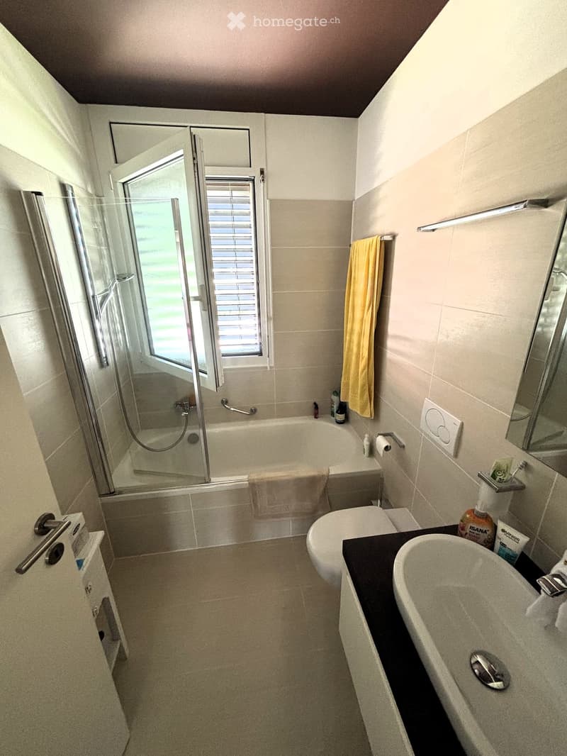 tiled floor, walk-in shower, bathtub, sink, toilet, towel hanging, mirror, toiletries