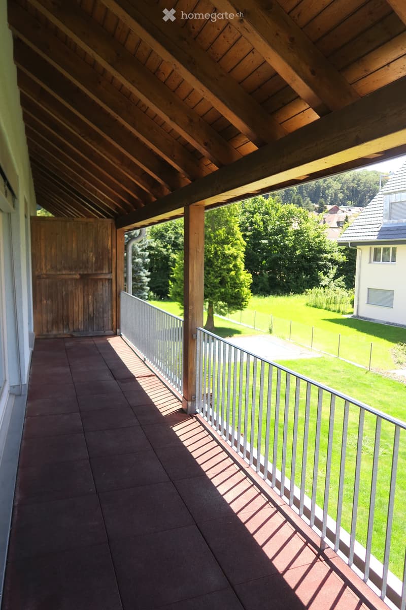 balcony with wooden floor, metal railings, green lawn view