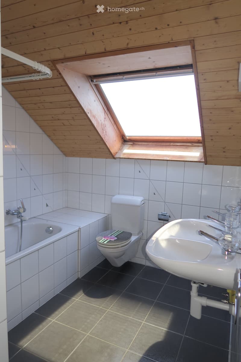 Bathroom with bathtub, toilet, sink, and window