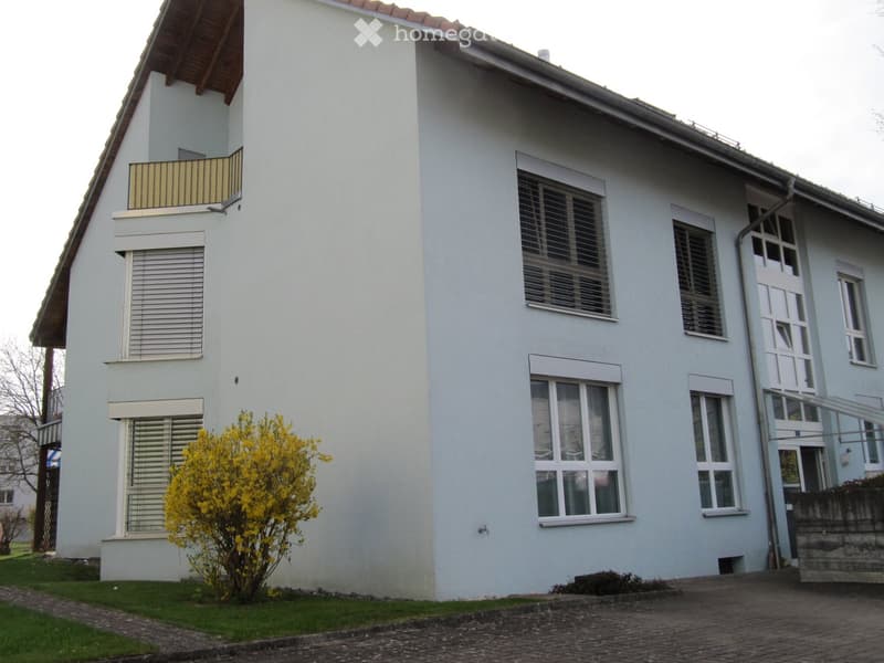 2 story house, white wall, multiple windows, balcony, yellow flower bush