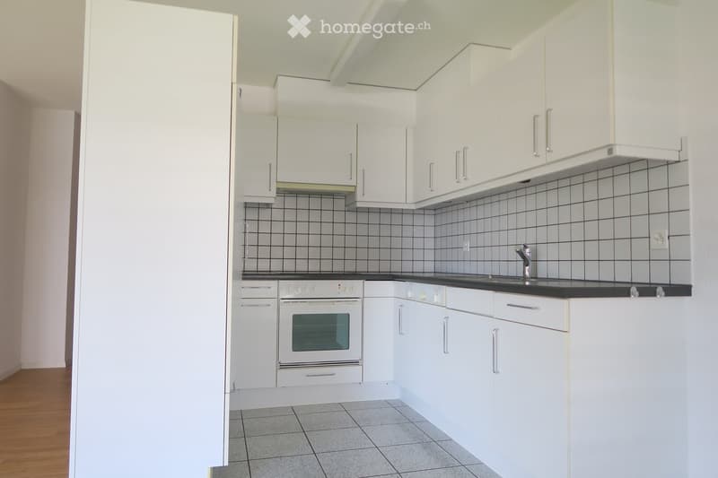 White kitchen with tiled floor, white cabinetry, gas stove, dishwasher, under cabinet sink with faucet, range hood, electrical outlets, no visible window
