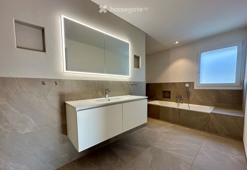 modern bathroom with white vanity, large mirror, bathtub, and tiled floor