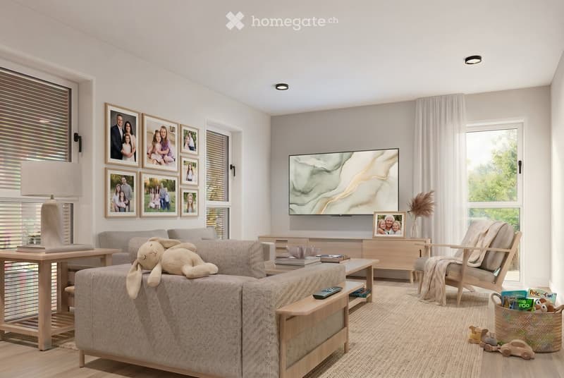 A modern living room with a grey sectional sofa, a wooden coffee table, a chair, a table lamp, a television, picture frames, a basket with toys, and books on the coffee table.