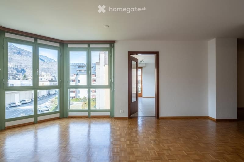wooden floor, panoramic windows, open door to another room, view of mountains and cityscape