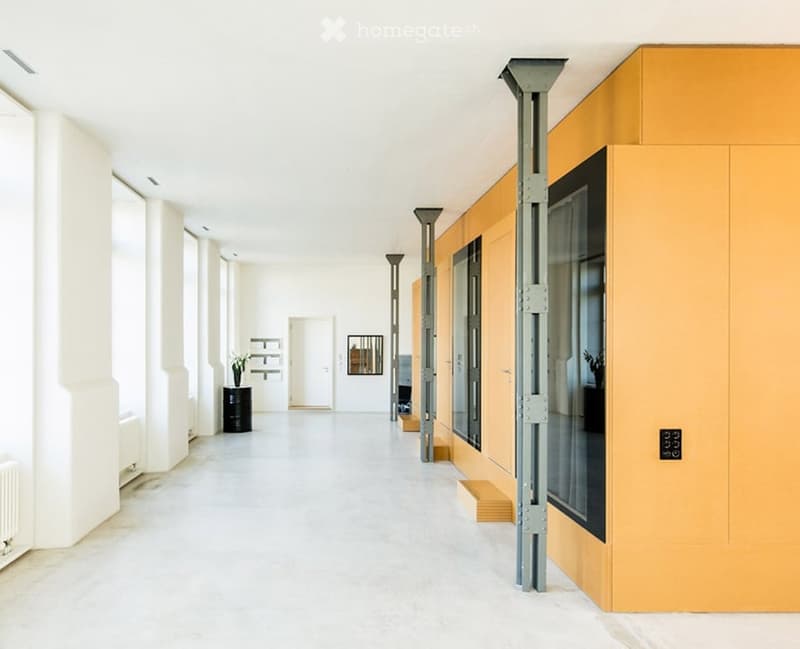 Modern, minimalist hallway with white walls, polished concrete floor, and large windows on one side. Features include a small black cabinet with a vase, a framed artwork on the wall, and a glass door leading to another room.