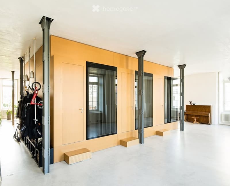 Modern, minimalist room with a large piano, a small stool, a tall storage unit with a bicycle, and large windows with curtains.