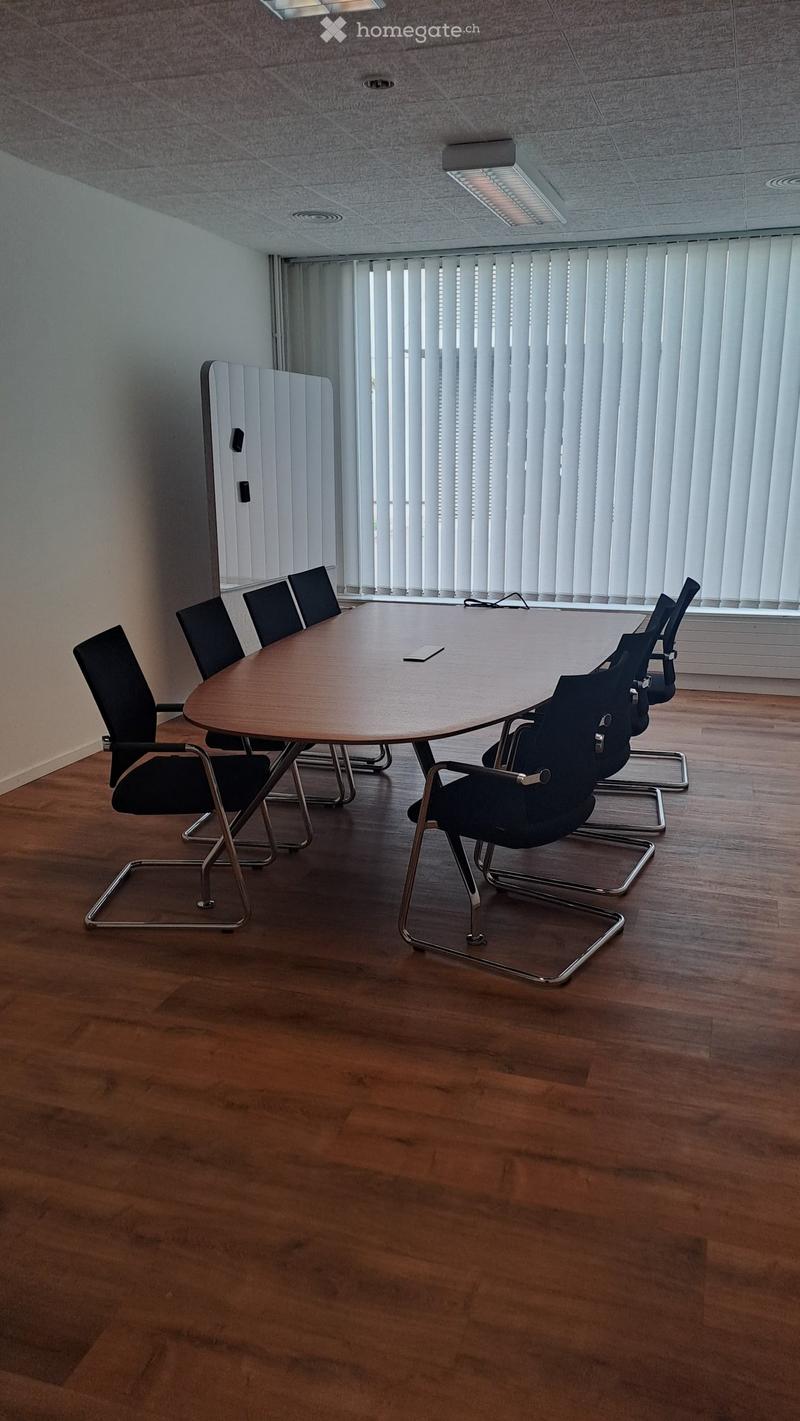 conference room, long wooden table, office chairs, windows with white blinds, blank wall