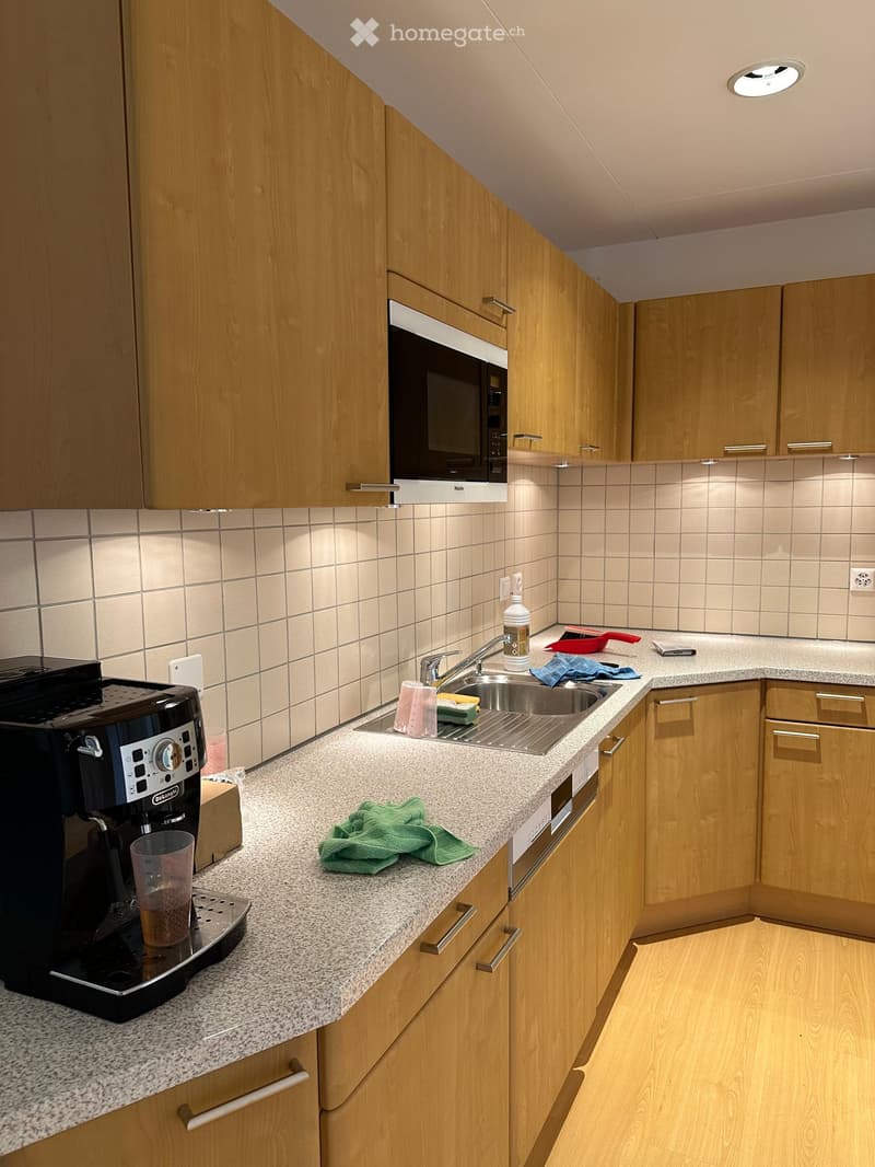 modern kitchen with wooden cabinets, granite countertop, stainless steel sink, dishwasher, coffee machine, white tiled walls