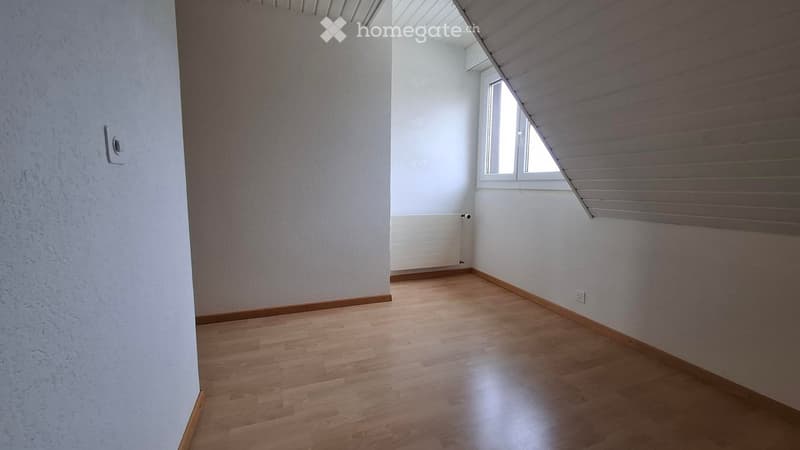 Empty room with wooden flooring, white walls, and a single window with blinds. No furniture or equipment present.