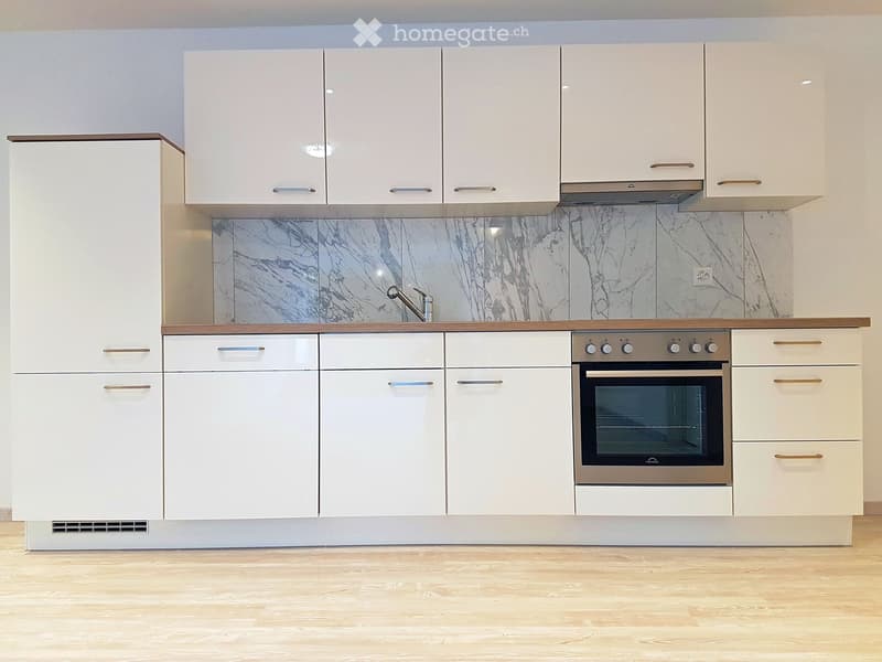 White kitchen with wooden cabinets, marble backsplash, stainless steel oven, modern faucet, wooden countertops, power outlet