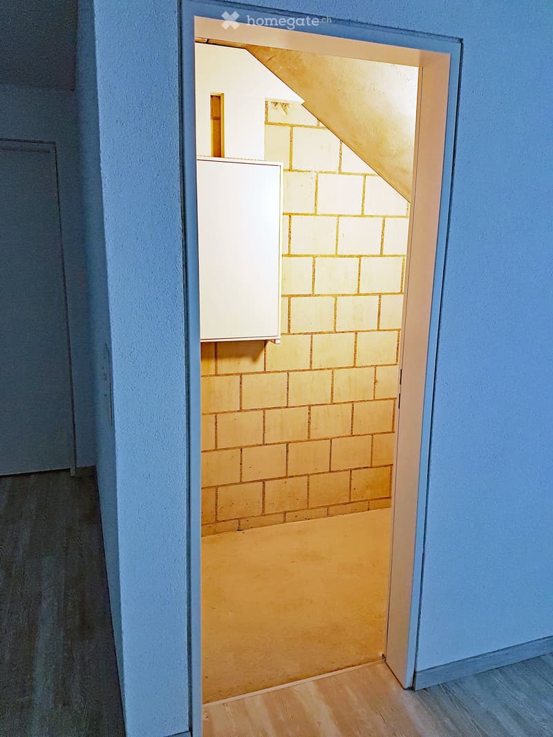 blue walls, wooden floor, yellow bricks, unfinished attic area, open door