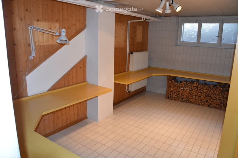 Empty room with wooden walls, tiled floor, built-in yellow shelves, and a stack of firewood in the corner. No furniture or equipment present.