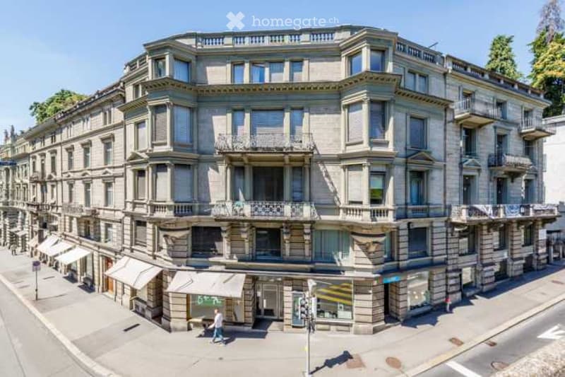 A multi-story building with classic architecture, multiple balconies, and large windows. The facade is made of stone with decorative elements.
