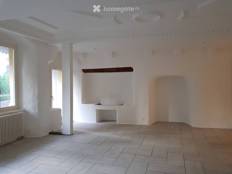 Empty room with white walls, tiled floor, and a small built-in bench. No furniture or equipment present.