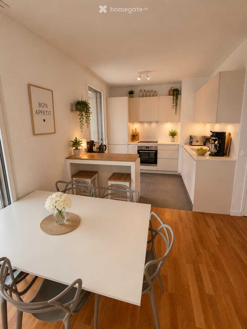 Modern kitchen with white cabinets, stainless steel appliances, wooden countertops, and a dining area with a white table and chairs.