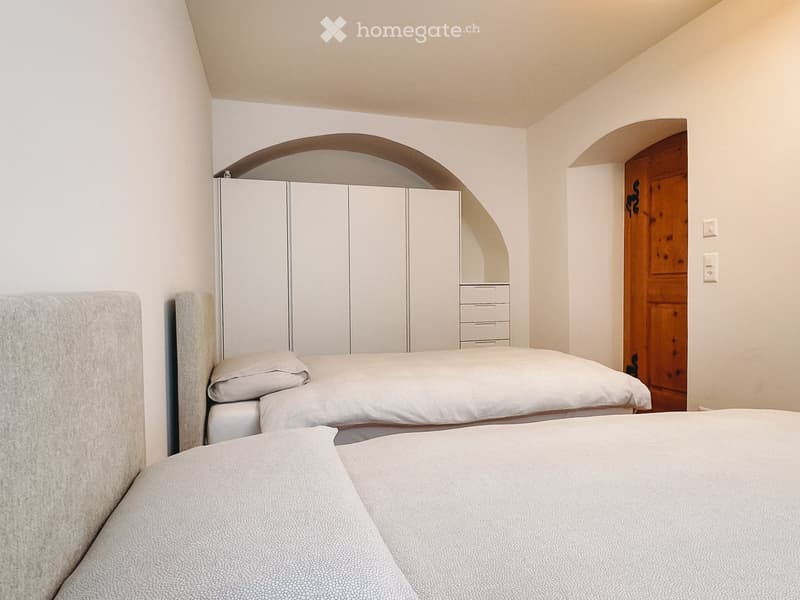 Bedroom. Cozy bedroom with two single beds, a modern wardrobe, and a wooden door leading to another room.