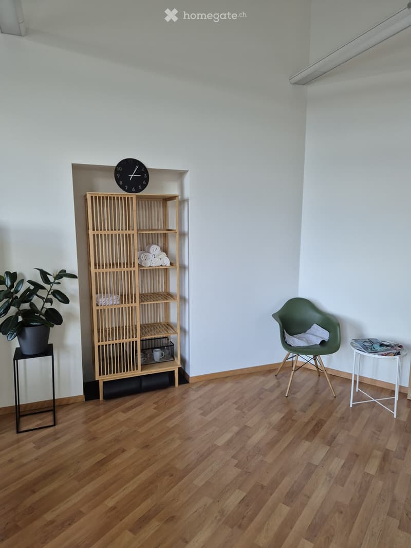 empty room, wooden floor, white walls, wooden shelf, white chair, white table, potted plant, clock, towels, cups