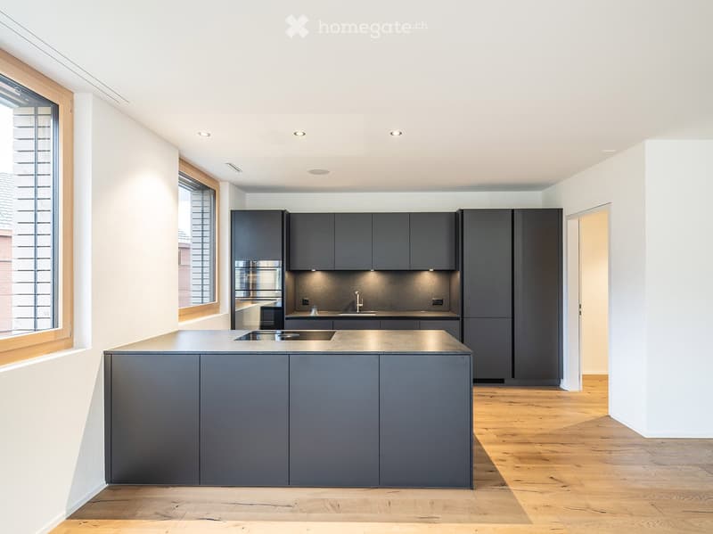 Open-plan kitchen with dark grey cabinets, central island, black granite countertop, modern appliances, large window, wooden flooring