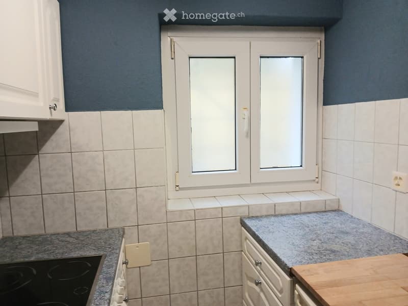 kitchen, white tiles, gray countertop, white cabinets, window with white frame