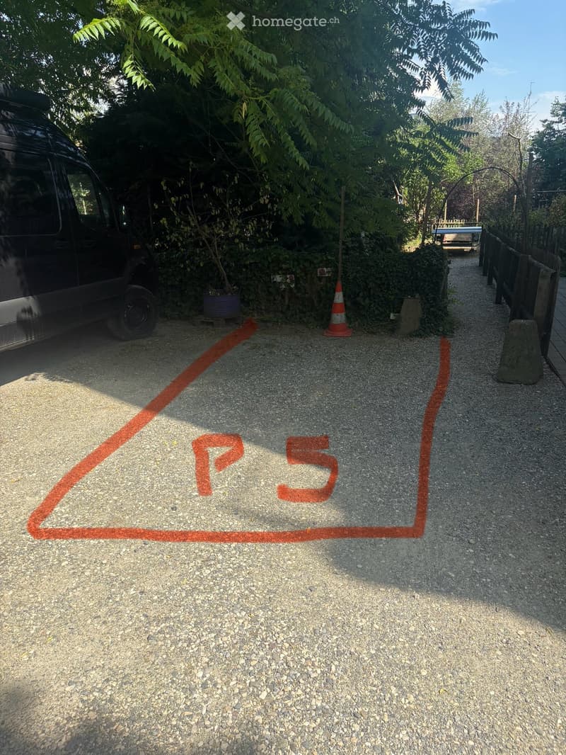Gravel driveway with a marked parking space labeled "P5" and a parked van on the left side.