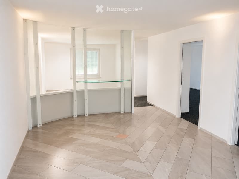 Empty room with light-colored tiled floor, white walls, and a glass shelf unit. No furniture or personal items are present.