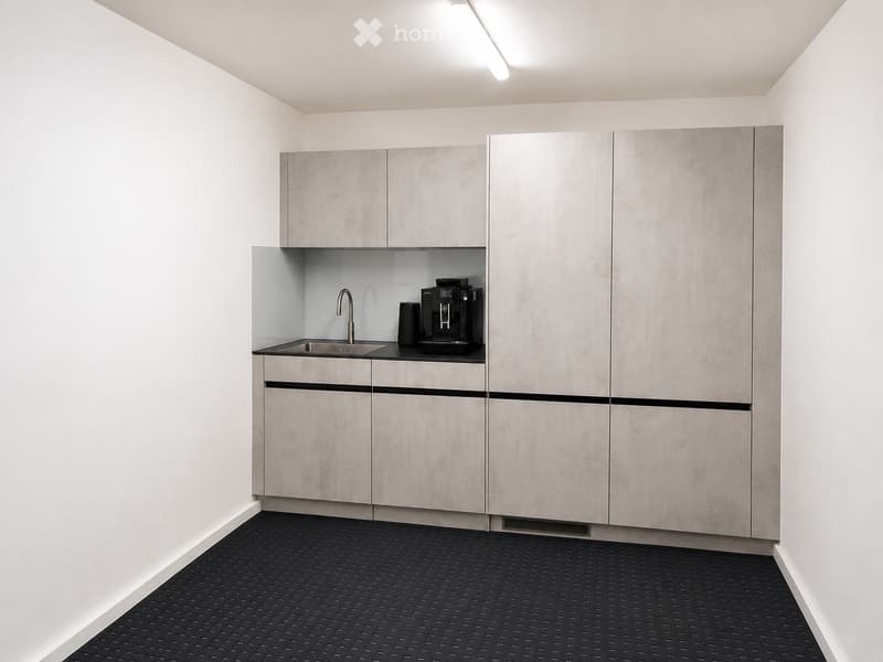 Modern kitchen with sleek, grey cabinets, a stainless steel sink, and a coffee machine on the counter.