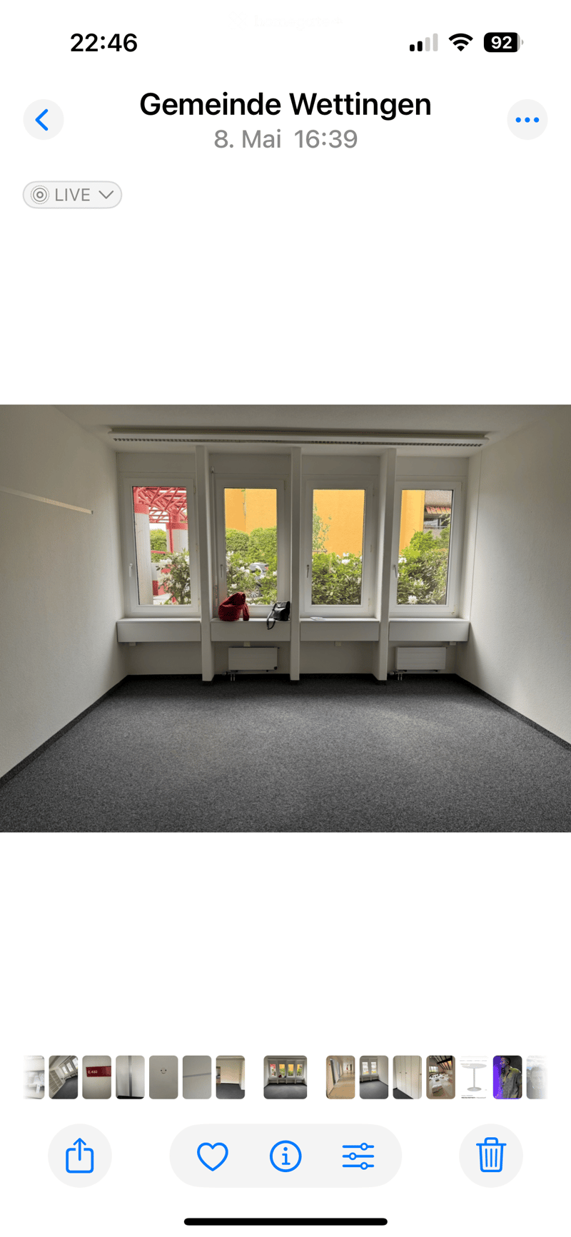 Empty room with grey carpet, white walls, large windows, and built-in window sills. No furniture or equipment visible.