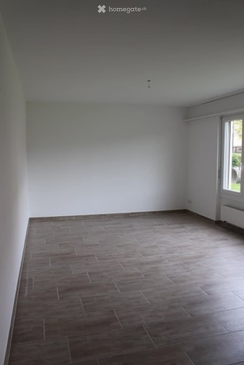 Completely empty room with white walls and wooden floor. No furniture or equipment.