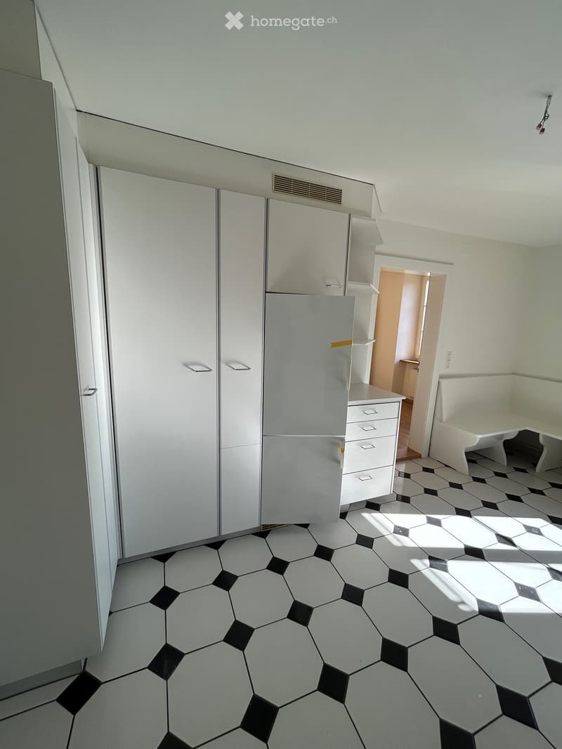 white floor, white walls, white doors, built-in closets, white shelves, small table, drawers