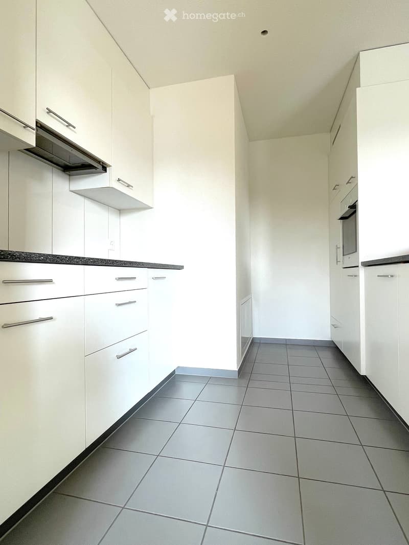 White cabinets, tiled floor, integrated dishwasher, built-in oven