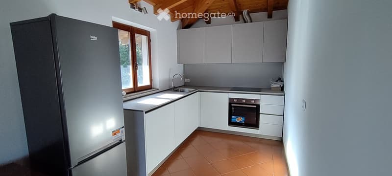 Modern kitchen with stainless steel refrigerator, sink, oven, cabinets, tiled floor