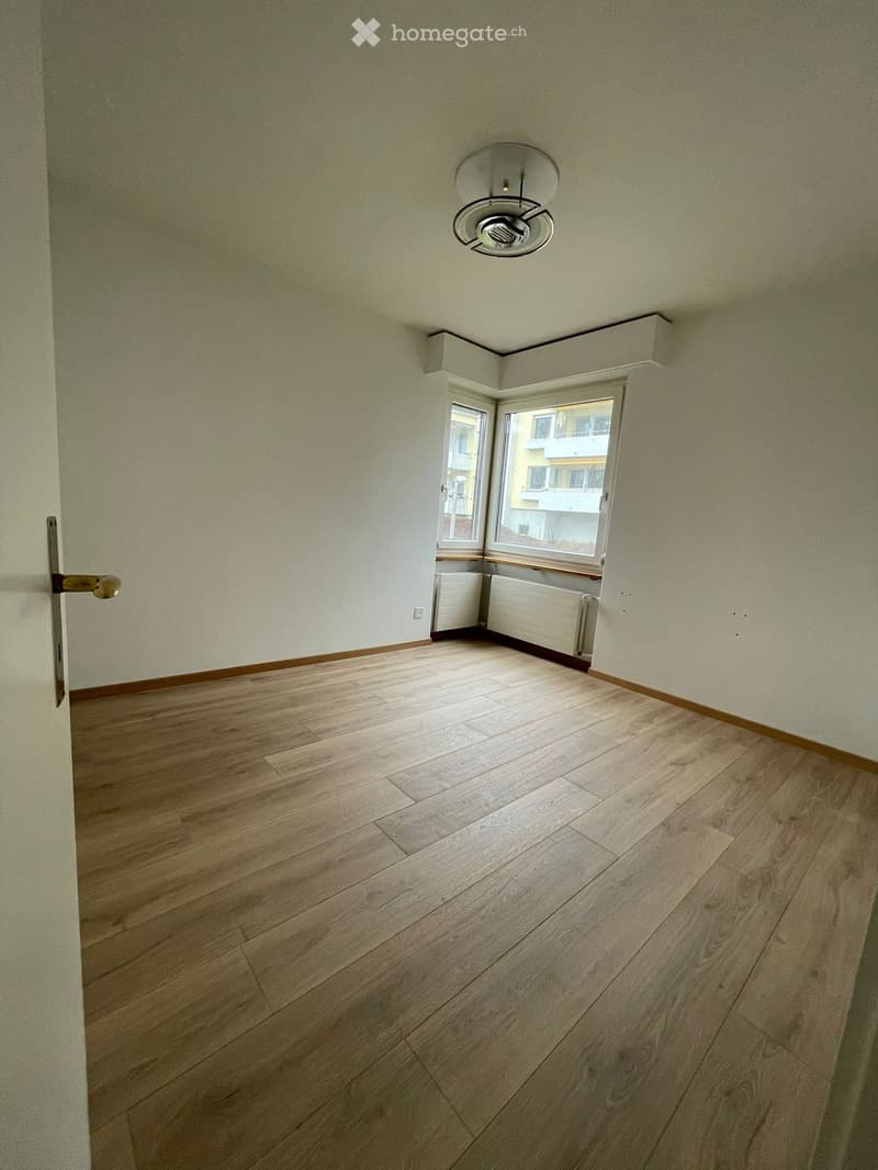 large windows, hardwood flooring, white walls, ceiling light