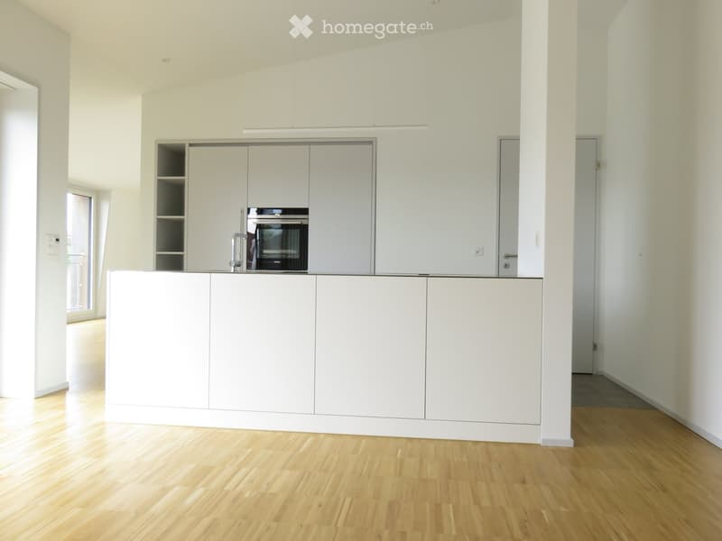 Modern, minimalist kitchen with white cabinets, a built-in oven, and a wooden floor.