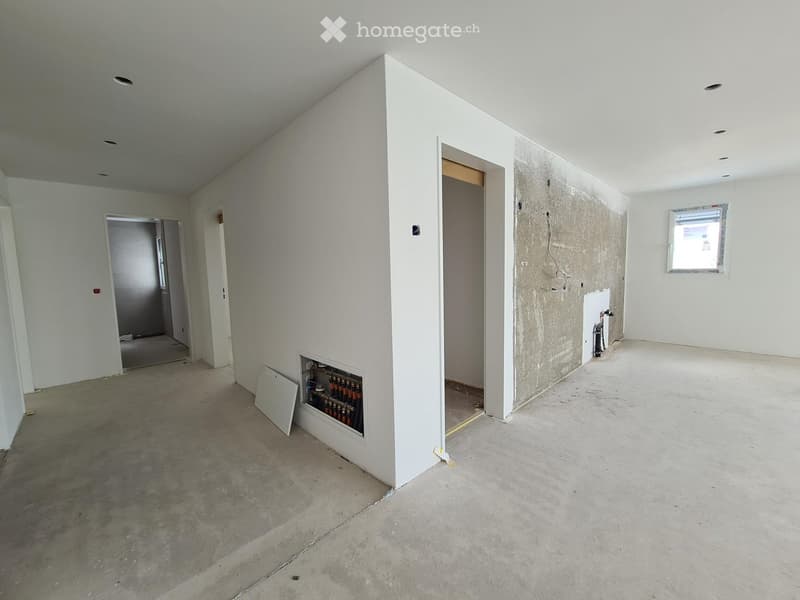 Empty room with white walls, concrete floor, and exposed pipes in a wall niche. No furniture or equipment present.